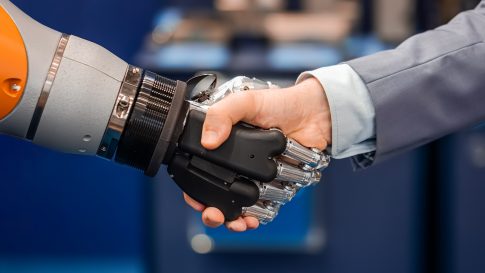 un homme et un robot font une poignée de main