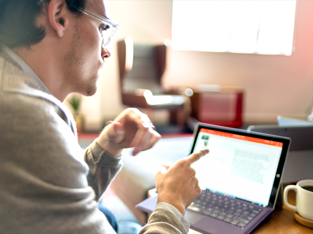 photo d'un homme sur son bureau avec un Surface Pro devant lui